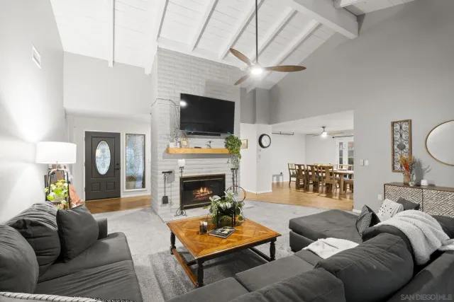 a living room with furniture a flat screen tv and a fireplace