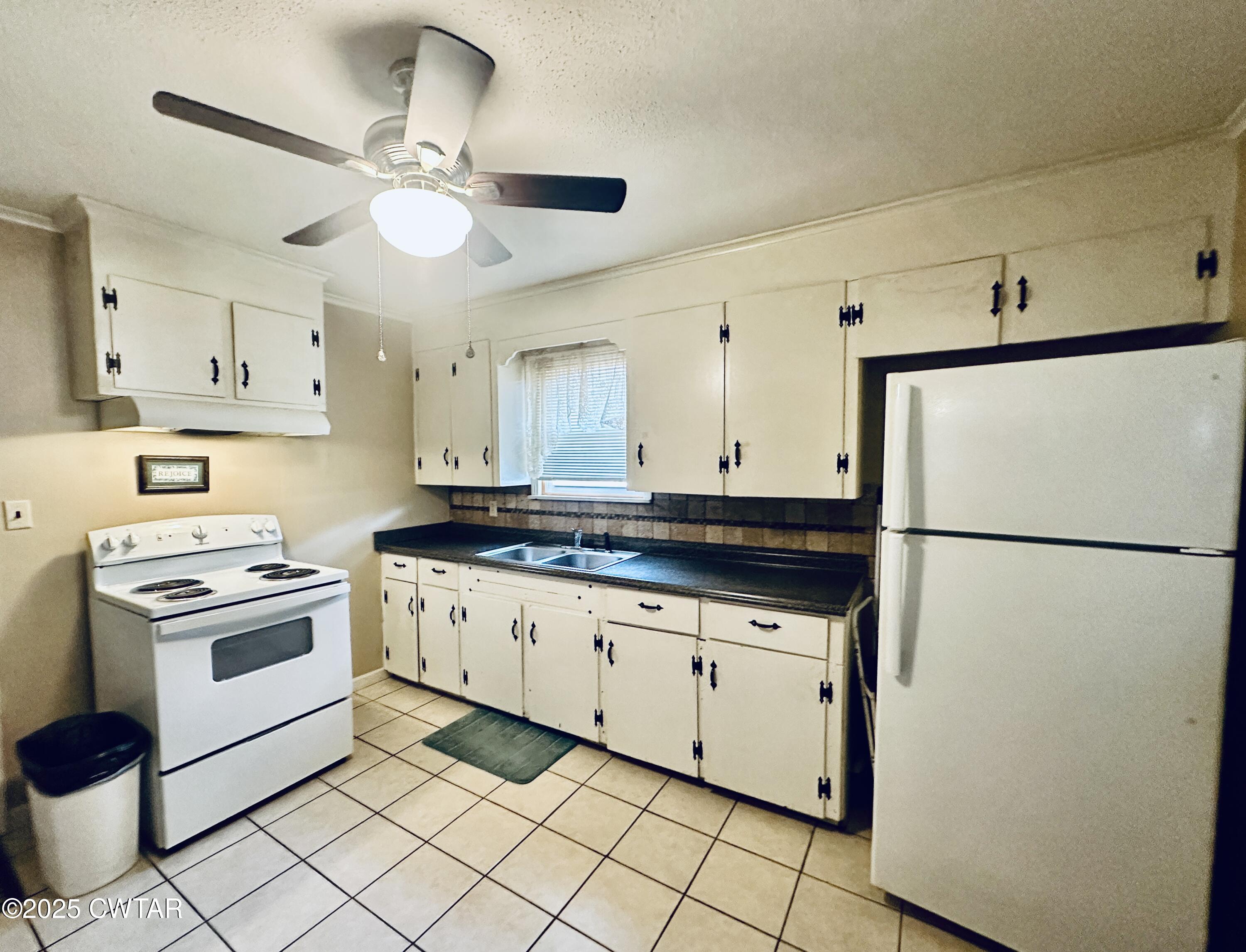 112 Fox Street Rutherford, TN 38369 - Photo 10 of 14 a kitchen with granite countertop cabinets a stove a sink and a refrigerator