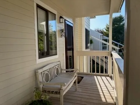 a view of a balcony with furniture and floor to ceiling window