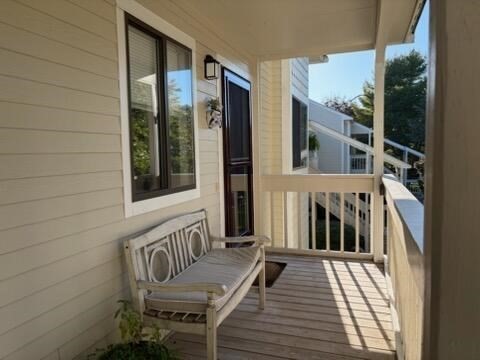 a view of a balcony with furniture and floor to ceiling window