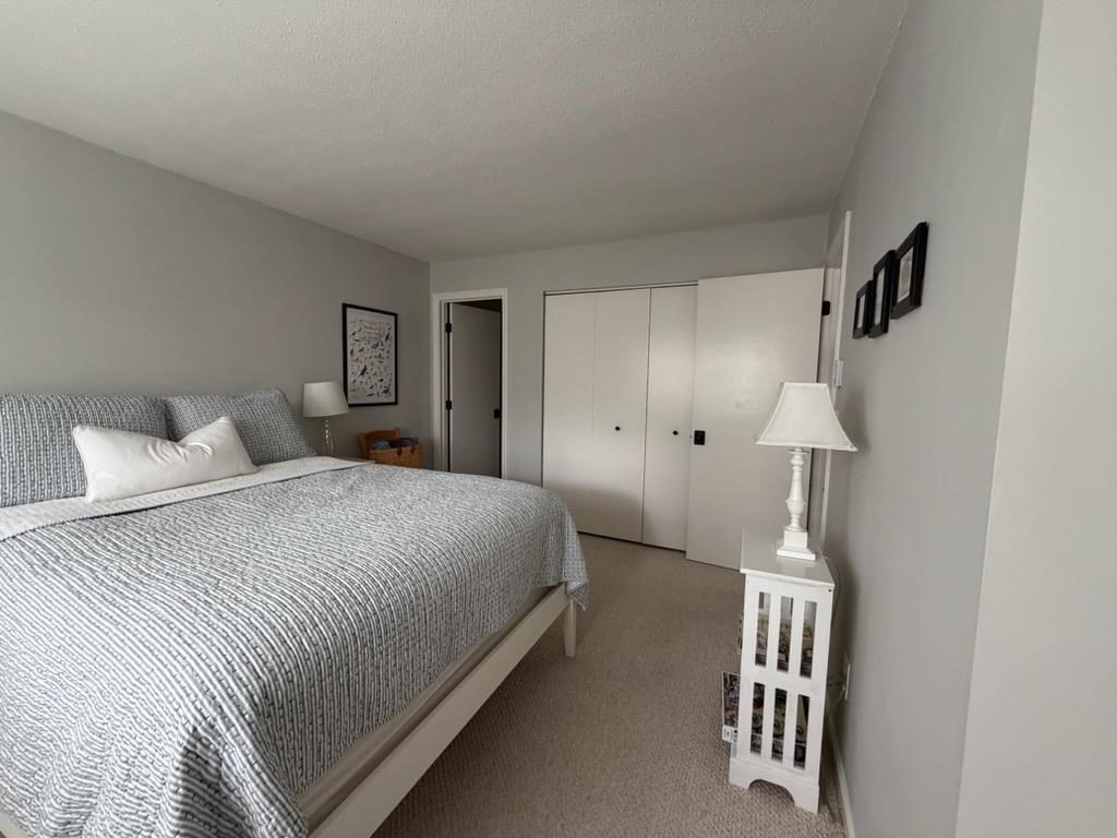 150 Eaton Lane, Unit 150 Brewster, MA 02631 - Photo 12 of 20 a bedroom with a white bed and a cabinets