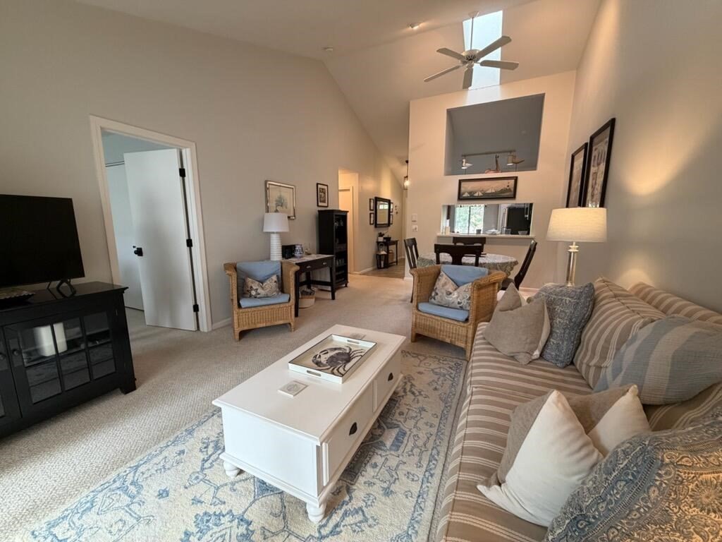 150 Eaton Lane, Unit 150 Brewster, MA 02631 - Photo 4 of 20 a living room with furniture a fireplace a flat screen tv and kitchen view