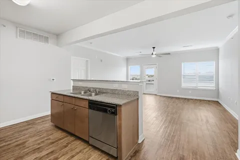 a kitchen with stainless steel appliances granite countertop a stove and a wooden floors