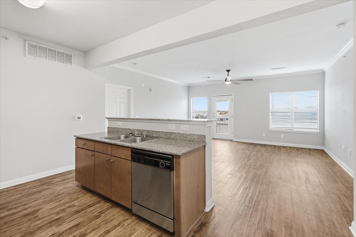 2502 Leon Street, Unit 414 Austin, TX 78705 - Photo 7 of 21 a kitchen with stainless steel appliances granite countertop a stove and a wooden floors
