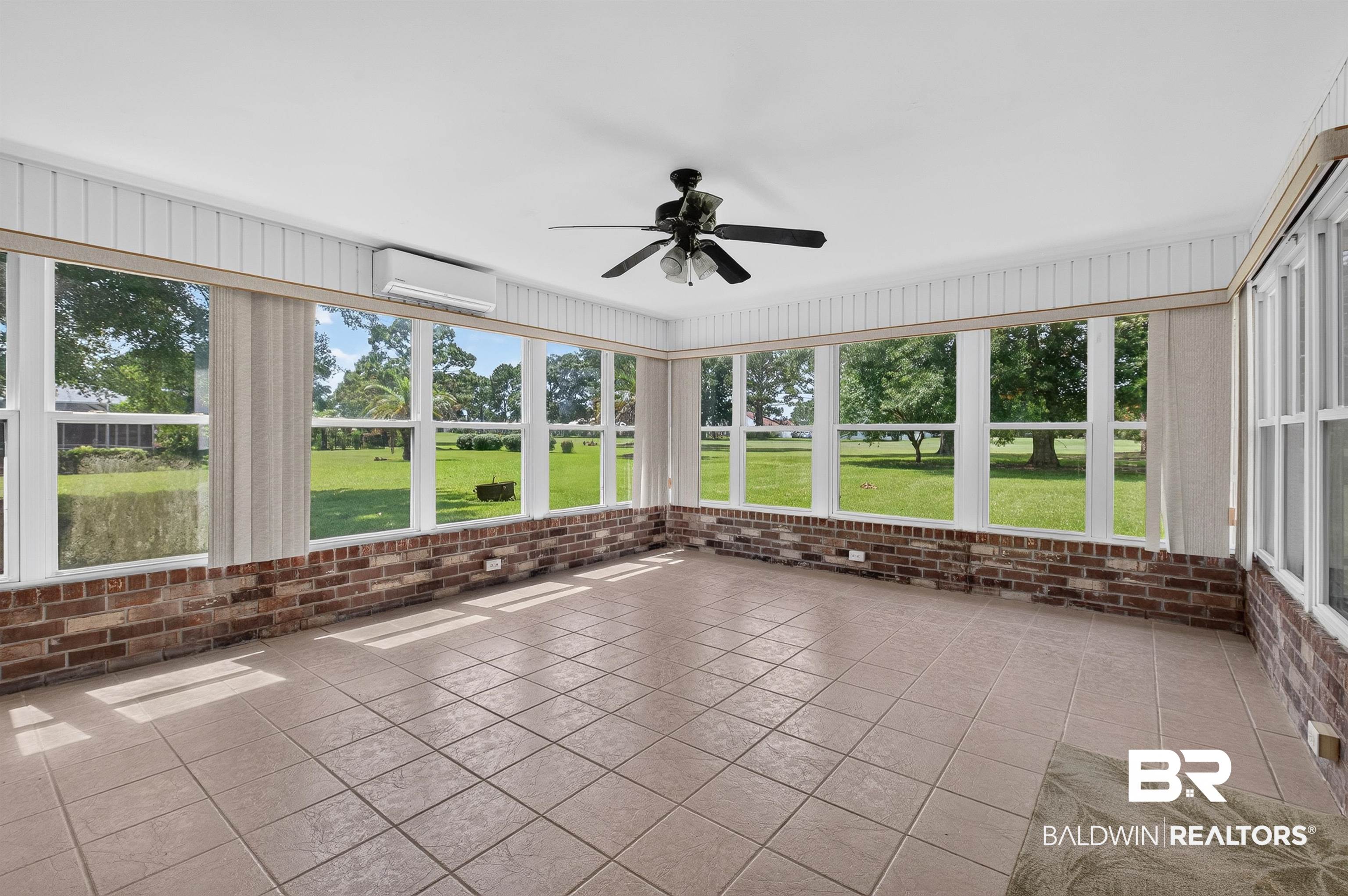 22685 County Road 12 Foley, AL 36535 - Photo 72 of 89 Sunroom featuring extensive window panels, a brick kneewall, tiled flooring, a ceiling fan, and a wall-mounted air conditioning unit