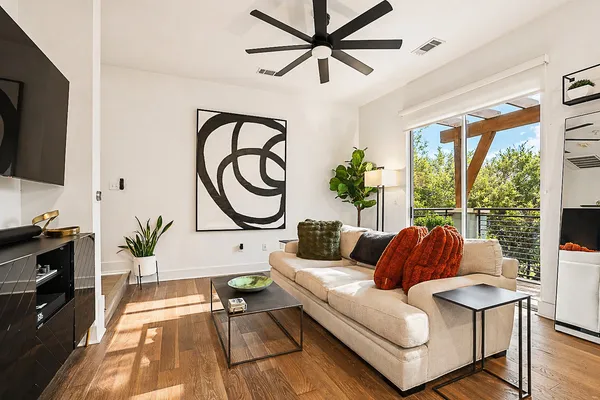 a living room with furniture a flat screen tv and a large window