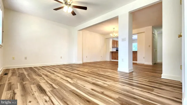 a view of a livingroom with wooden floor and a ceiling fan