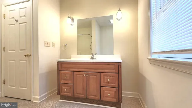 a bathroom with a granite countertop sink a mirror and a shower