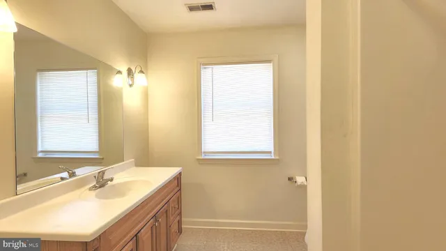 a bathroom with a granite countertop sink a mirror and a bathtub