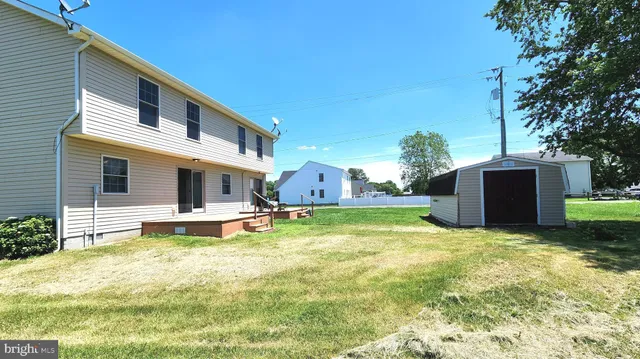 a view of a house with a big yard and a large tree