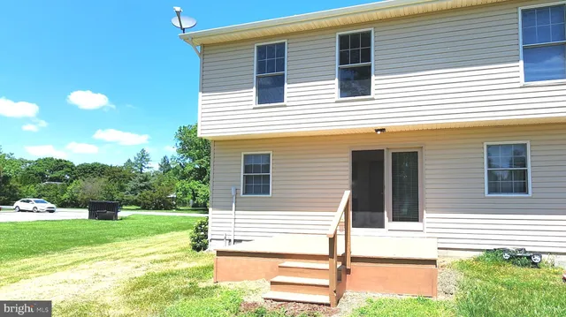a view of a house with backyard and a yard