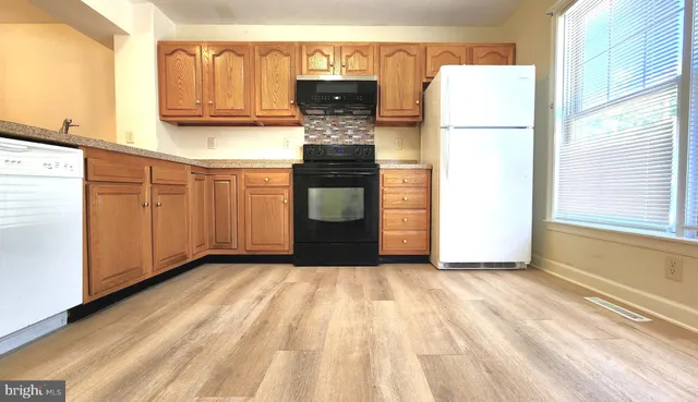 a view of kitchen with refrigerator cabinets and a window