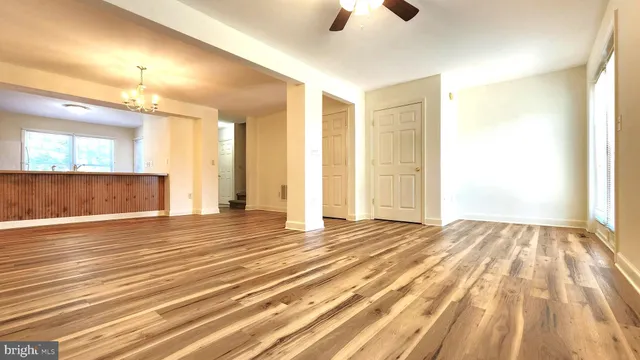 an empty room with wooden floor and windows