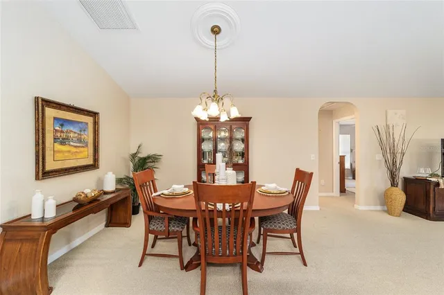 a kitchen with stainless steel appliances kitchen island granite countertop a stove top oven a sink a dining table and chairs