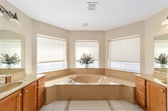 a spacious bathroom with a double vanity sink and a mirror