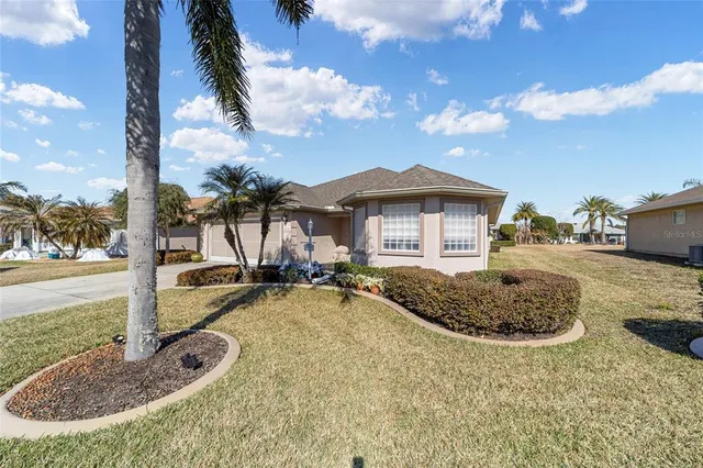 a view of a house with backyard and sitting area