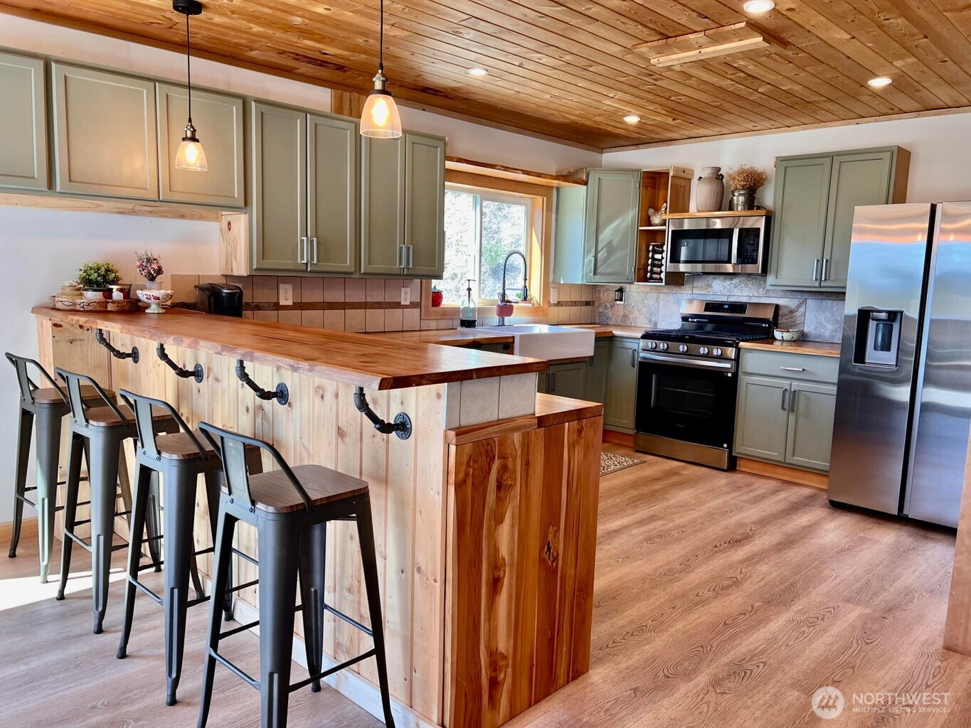 3705 Hope Way Kettle Falls, WA 99141 - Photo 12 of 37 a kitchen with stainless steel appliances granite countertop a table chairs sink and cabinets