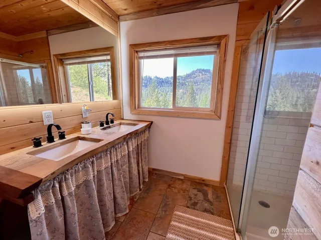 a view of a bedroom with wooden floor and windows