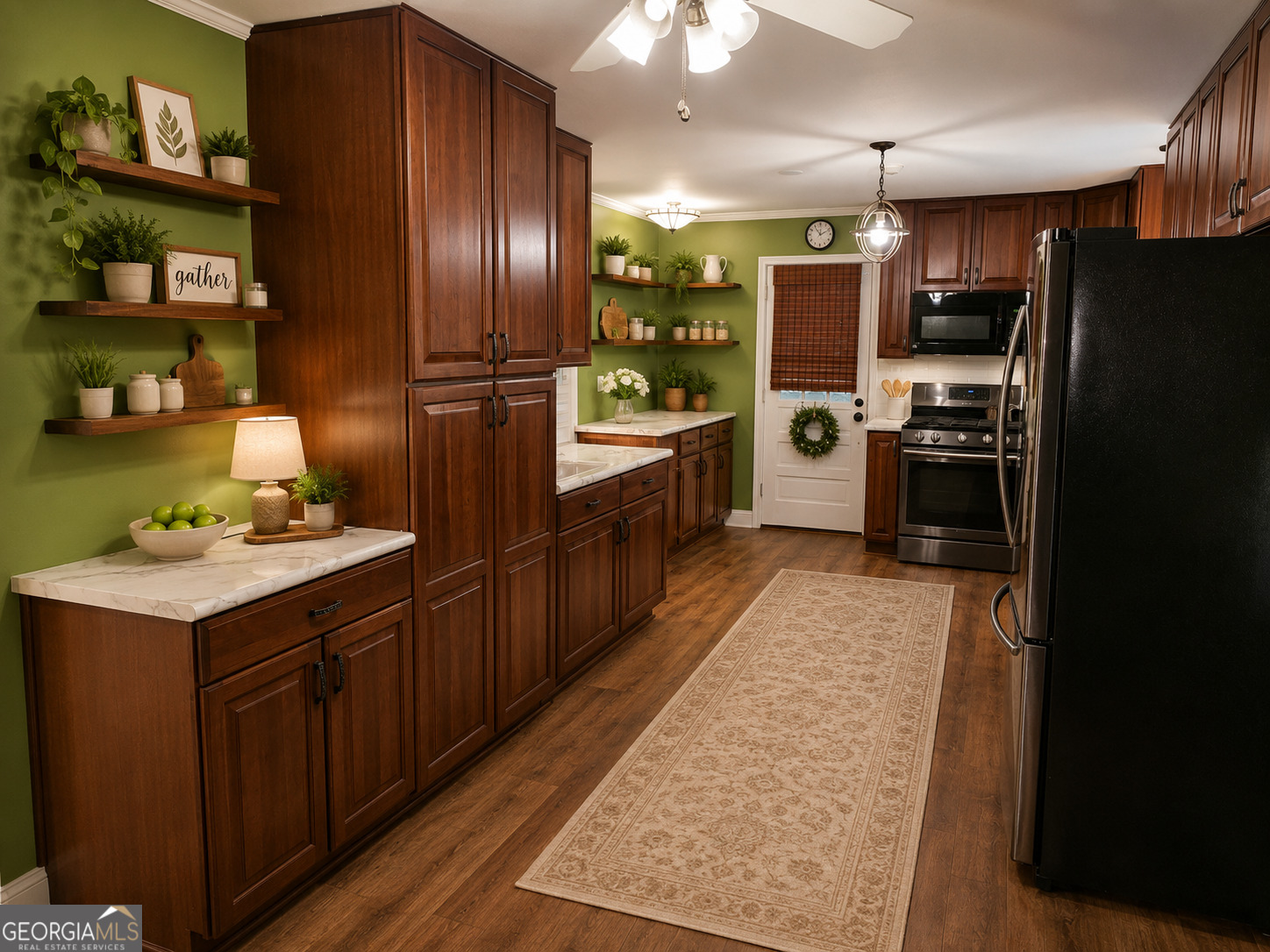 2615 Camak Road Warrenton, GA 30828 - Photo 7 of 21 Designed for both function and style, this spacious kitchen showcases rich wood cabinetry, stainless steel appliances, expansive countertops, and abundant storage, making meal preparation and entertaining effortless. Virtually enhanced and staged to