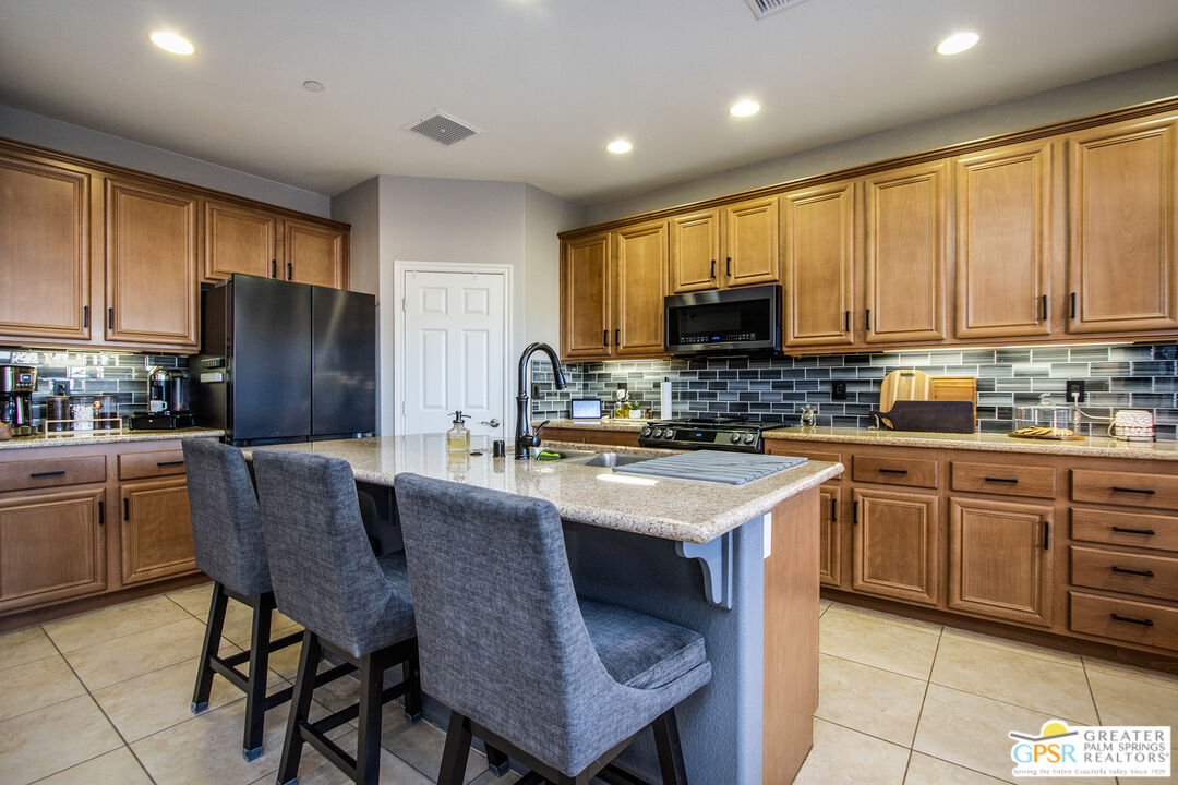 56166 Nez Perce Trail Yucca Valley, CA 92284 - Photo 15 of 54 a kitchen with stainless steel appliances granite countertop a stove a refrigerator a sink a stove a dining table and chairs