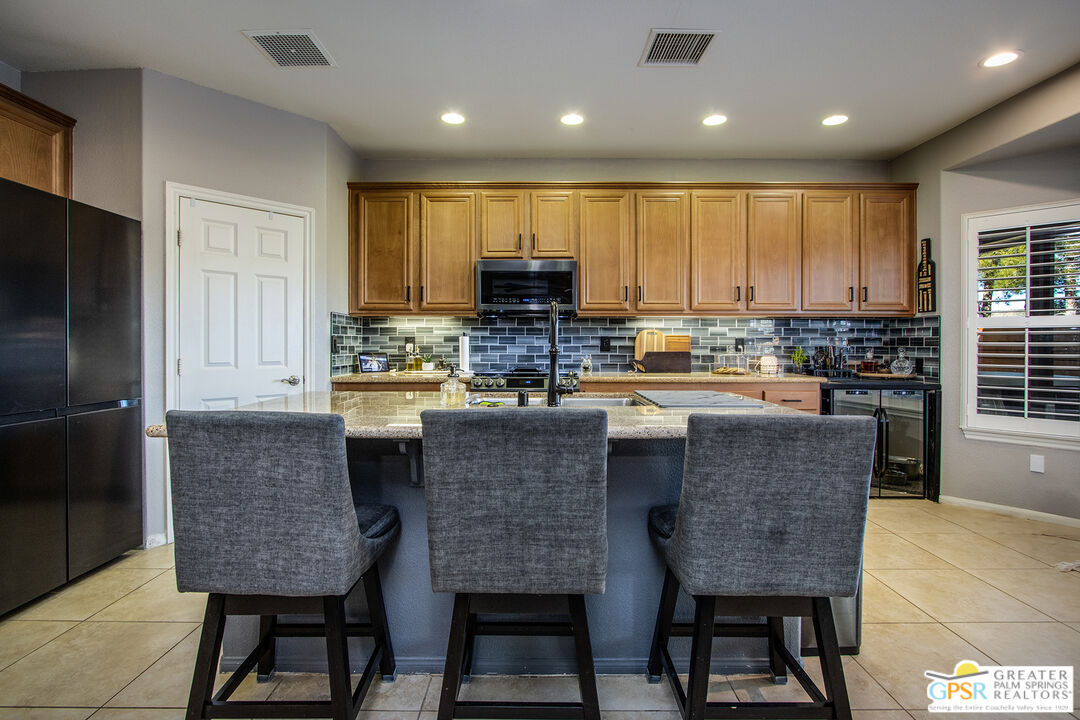 56166 Nez Perce Trail Yucca Valley, CA 92284 - Photo 18 of 54 a kitchen with kitchen island granite countertop a stove a sink a refrigerator a center island and a cabinets