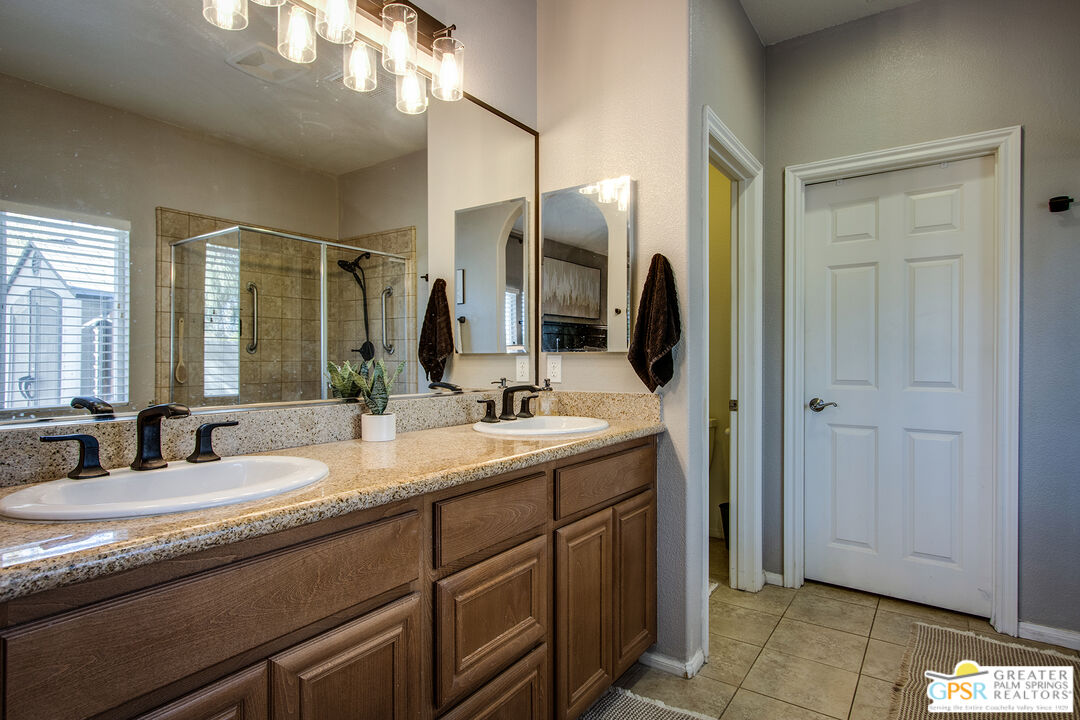 56166 Nez Perce Trail Yucca Valley, CA 92284 - Photo 25 of 54 a bathroom with a granite countertop sink and a mirror