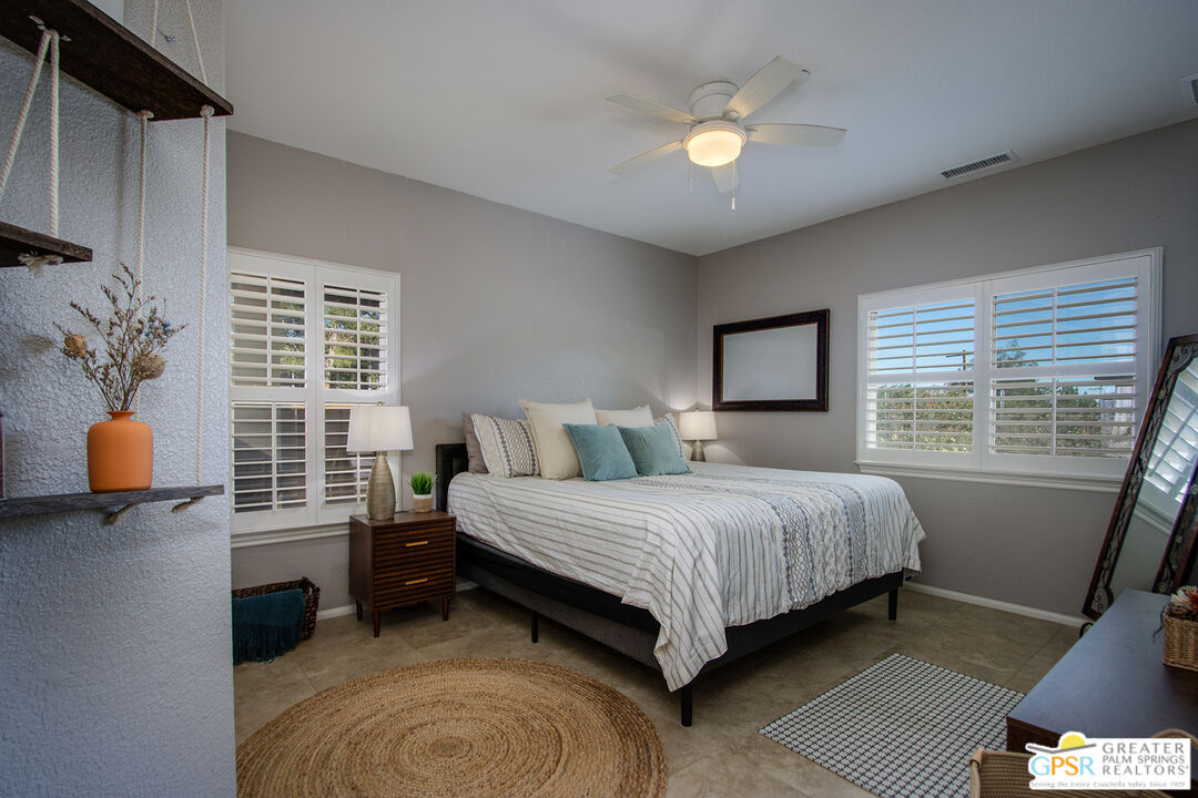 56166 Nez Perce Trail Yucca Valley, CA 92284 - Photo 28 of 54 a spacious bedroom with a bed and a chandelier