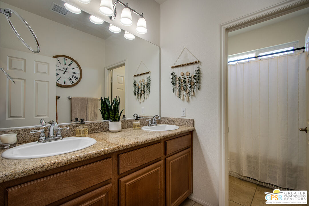 56166 Nez Perce Trail Yucca Valley, CA 92284 - Photo 29 of 54 a bathroom with a granite countertop sink a large mirror and a shower