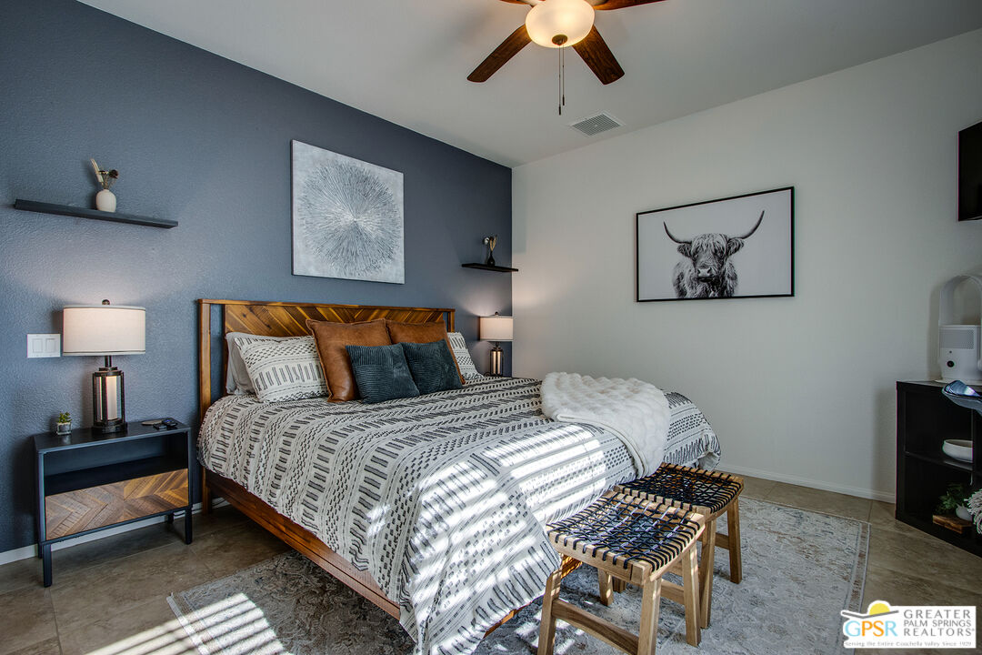 56166 Nez Perce Trail Yucca Valley, CA 92284 - Photo 32 of 54 a bedroom with bed and a chandelier