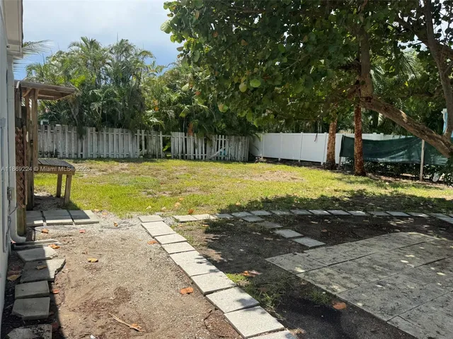 a front view of a house with garden space and palm tree
