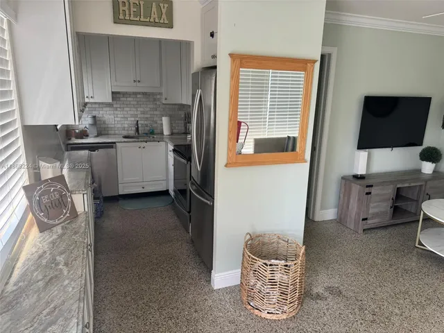 a view of hallway with furniture and a refrigerator