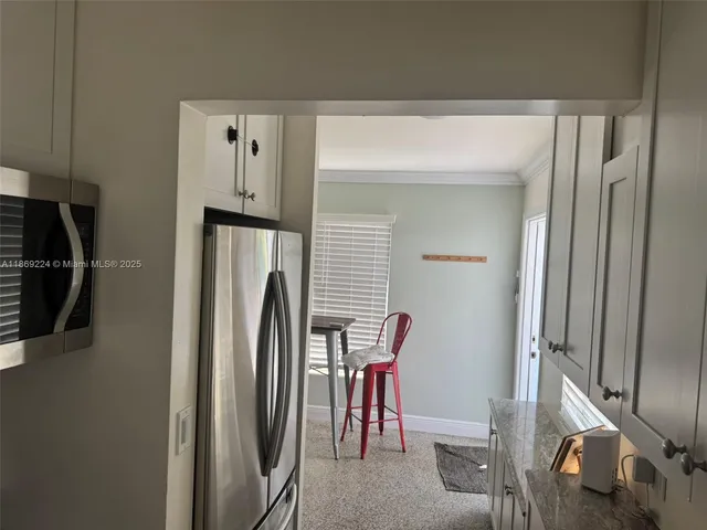 a hallway with a white cabinets and wooden floor