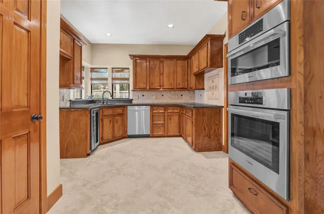 a kitchen with stainless steel appliances granite countertop a stove top oven a sink and dishwasher
