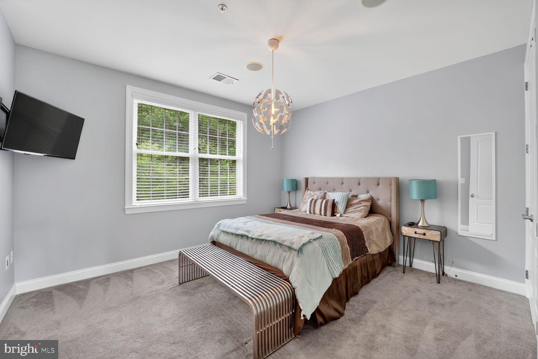 16831 Swanson Road Upper Marlboro, MD 20774 - Photo 36 of 56 a spacious bedroom with a bed and a flat screen tv