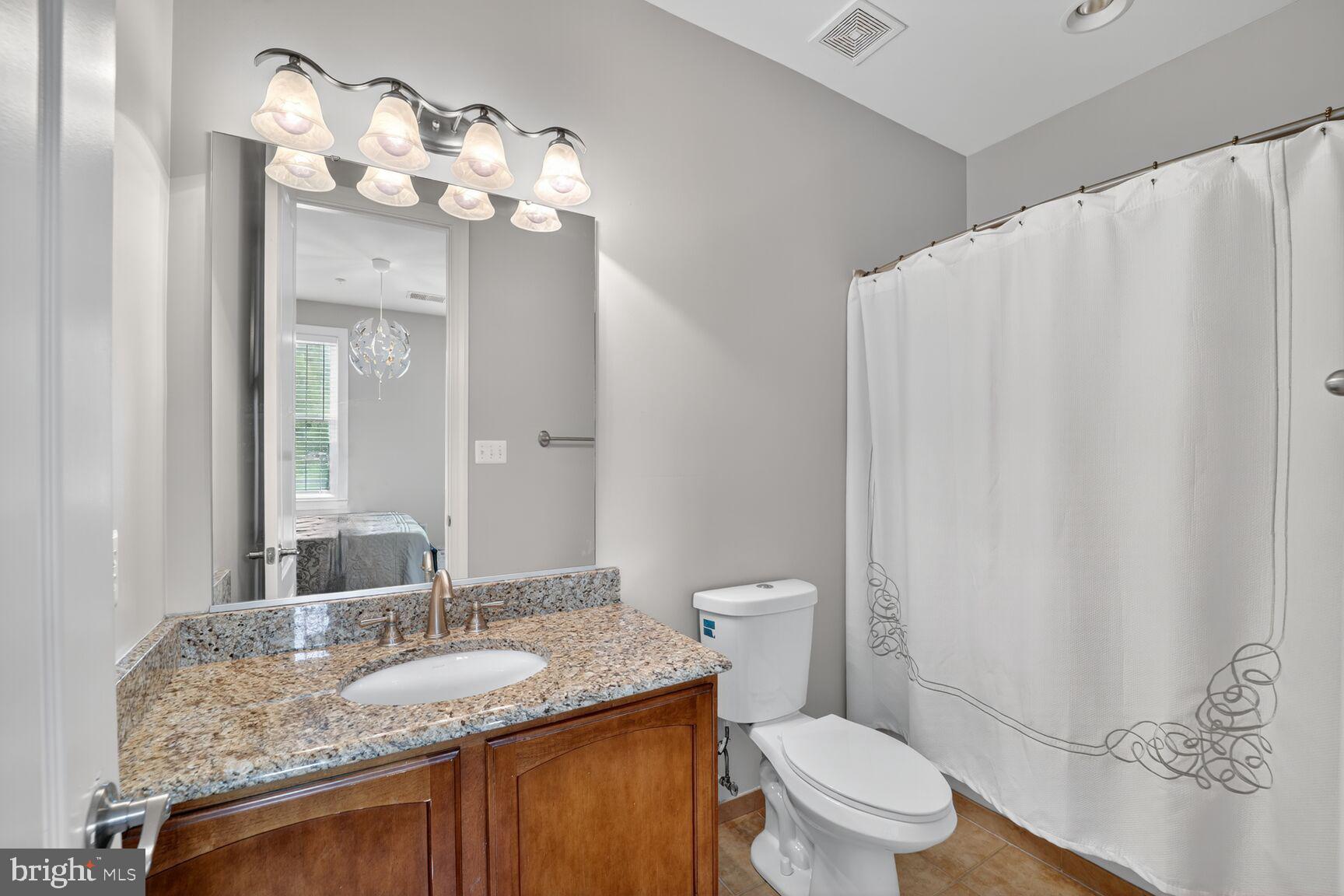 16831 Swanson Road Upper Marlboro, MD 20774 - Photo 39 of 56 a bathroom with a granite countertop sink a toilet and a mirror