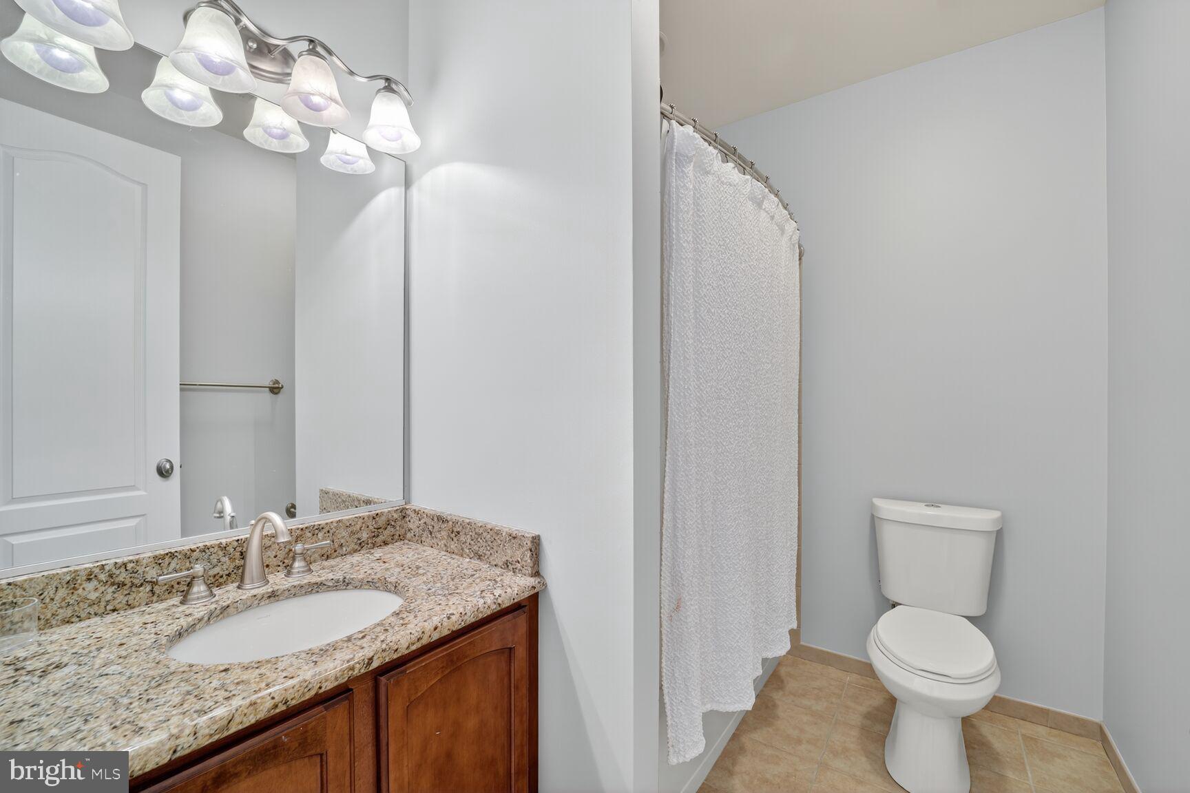 16831 Swanson Road Upper Marlboro, MD 20774 - Photo 40 of 56 a bathroom with a granite countertop sink toilet and a mirror