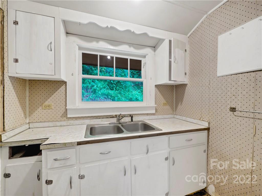 2731 Redmon Road Marshall, NC 28753 - Photo 20 of 43 a kitchen with stainless steel appliances granite countertop a sink a stove and white cabinets
