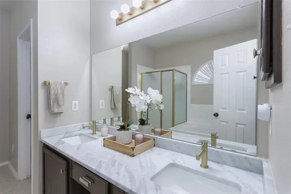a bathroom with double vanity sinks and a mirror