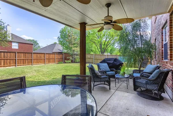 a view of a patio with a table chairs and a yard