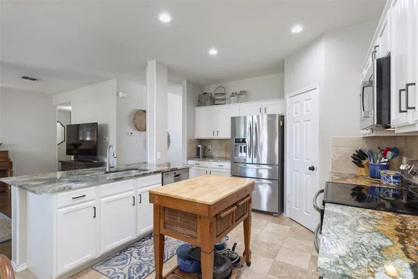 a kitchen that has a stove a sink and a refrigerator