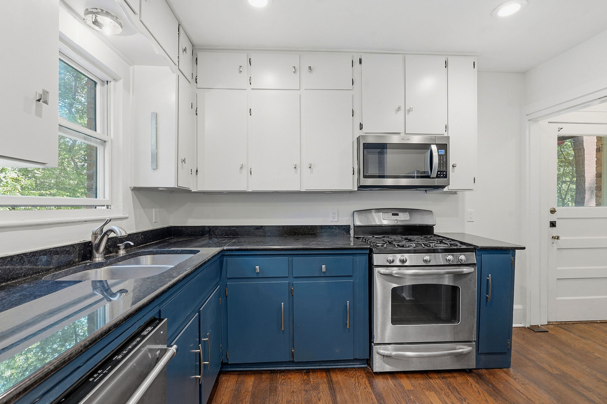 804 Rutherford Place, Unit A Austin, TX 78704 - Photo 8 of 17 a kitchen with granite countertop a stove a sink and wooden cabinets
