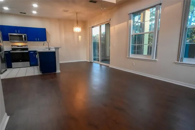 wooden floor with kitchen view and a window