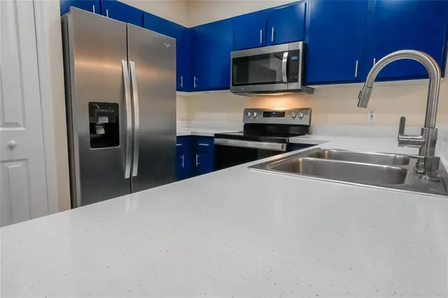 a kitchen with stainless steel appliances wooden cabinets a sink and a microwave