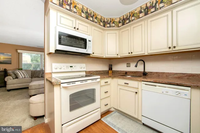 a kitchen with stainless steel appliances granite countertop a stove and white cabinets