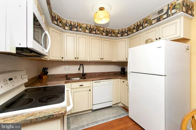 a kitchen with stainless steel appliances granite countertop a stove and white cabinets