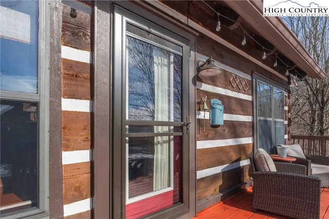 a view of a roof deck with couches and wooden fence