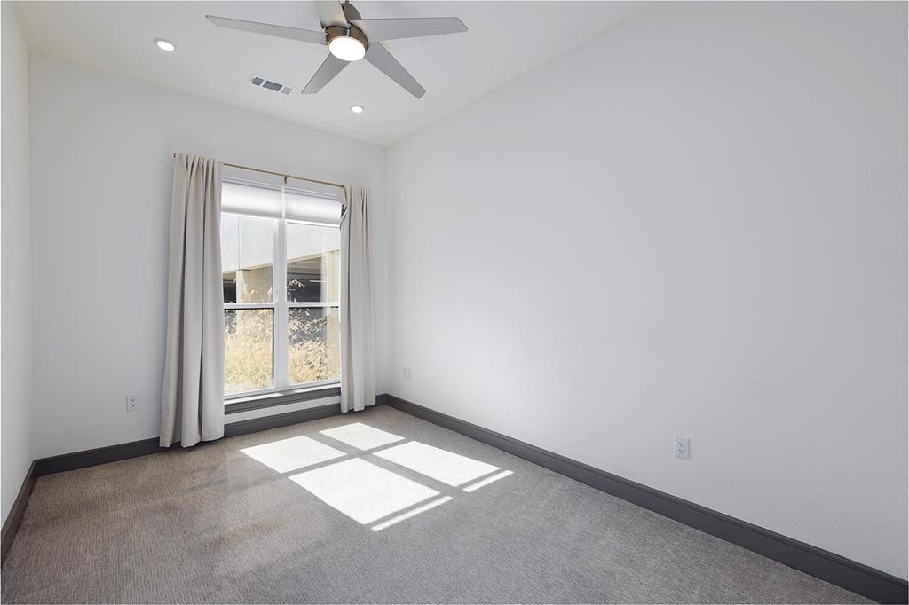 2700 Old Denton Road, Unit 1044 Carrollton, TX 75007 - Photo 10 of 33 Carpeted room with a large window, recessed lighting, and a ceiling fan