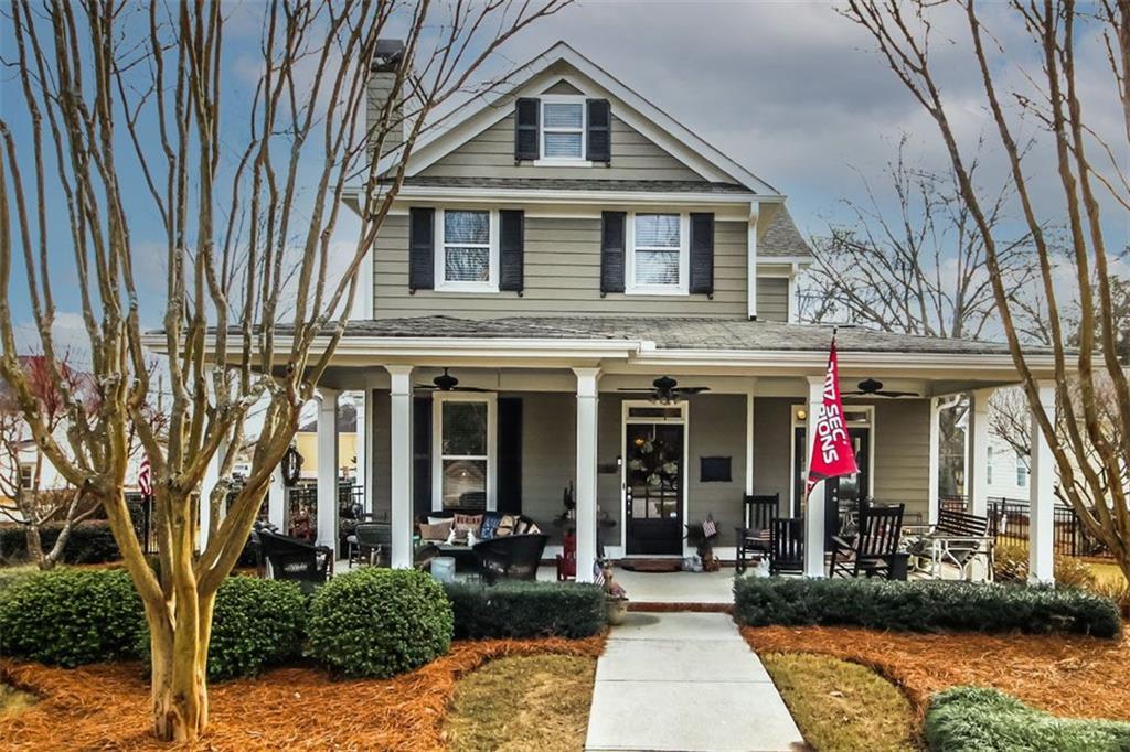 a view of a brick house with large windows and plants