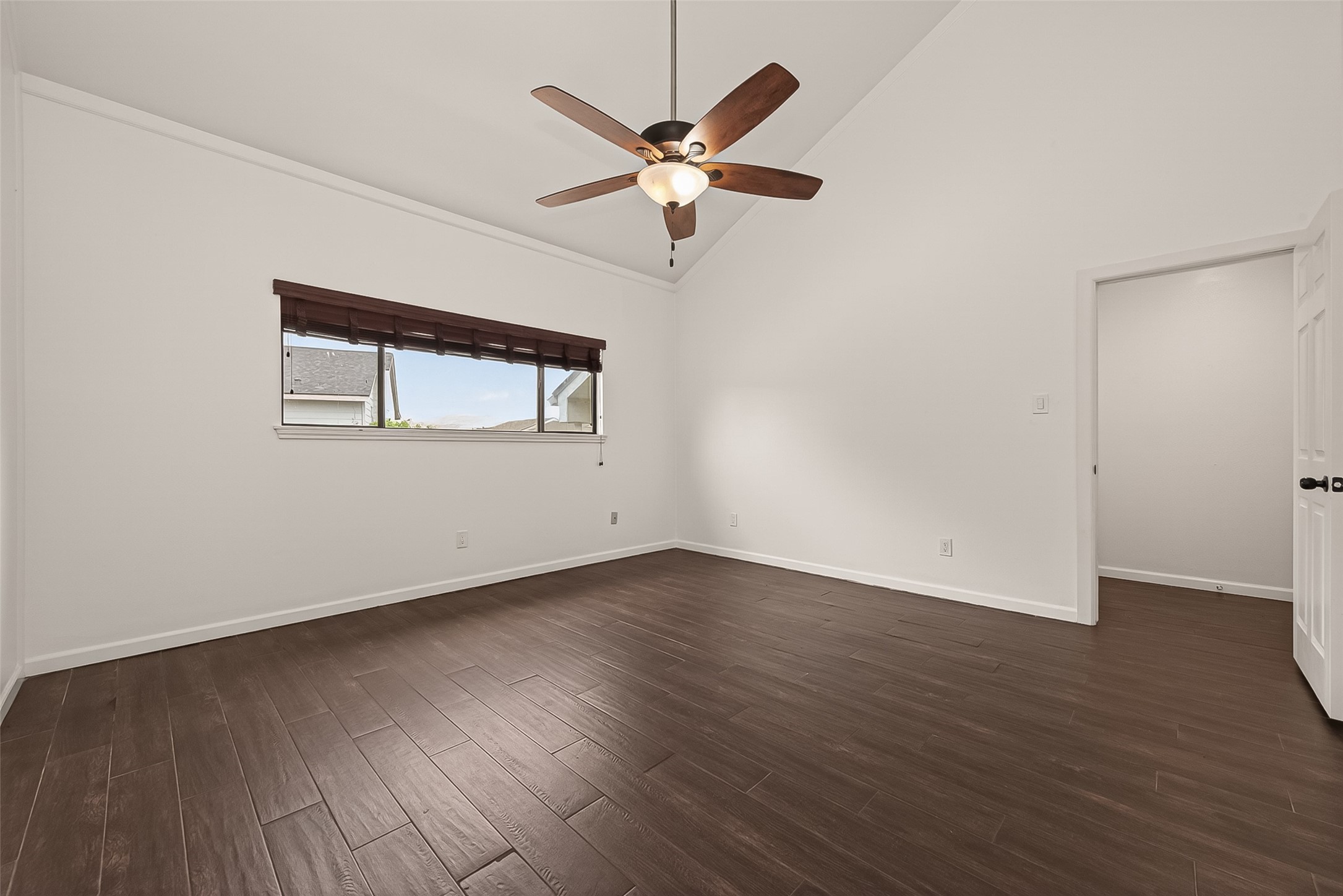 180 April Point Drive South Conroe, TX 77356 - Photo 16 of 39 This spacious room features high ceilings, a ceiling fan, and dark wood flooring. A large window provides natural light, and the neutral walls offer a bright, airy feel.