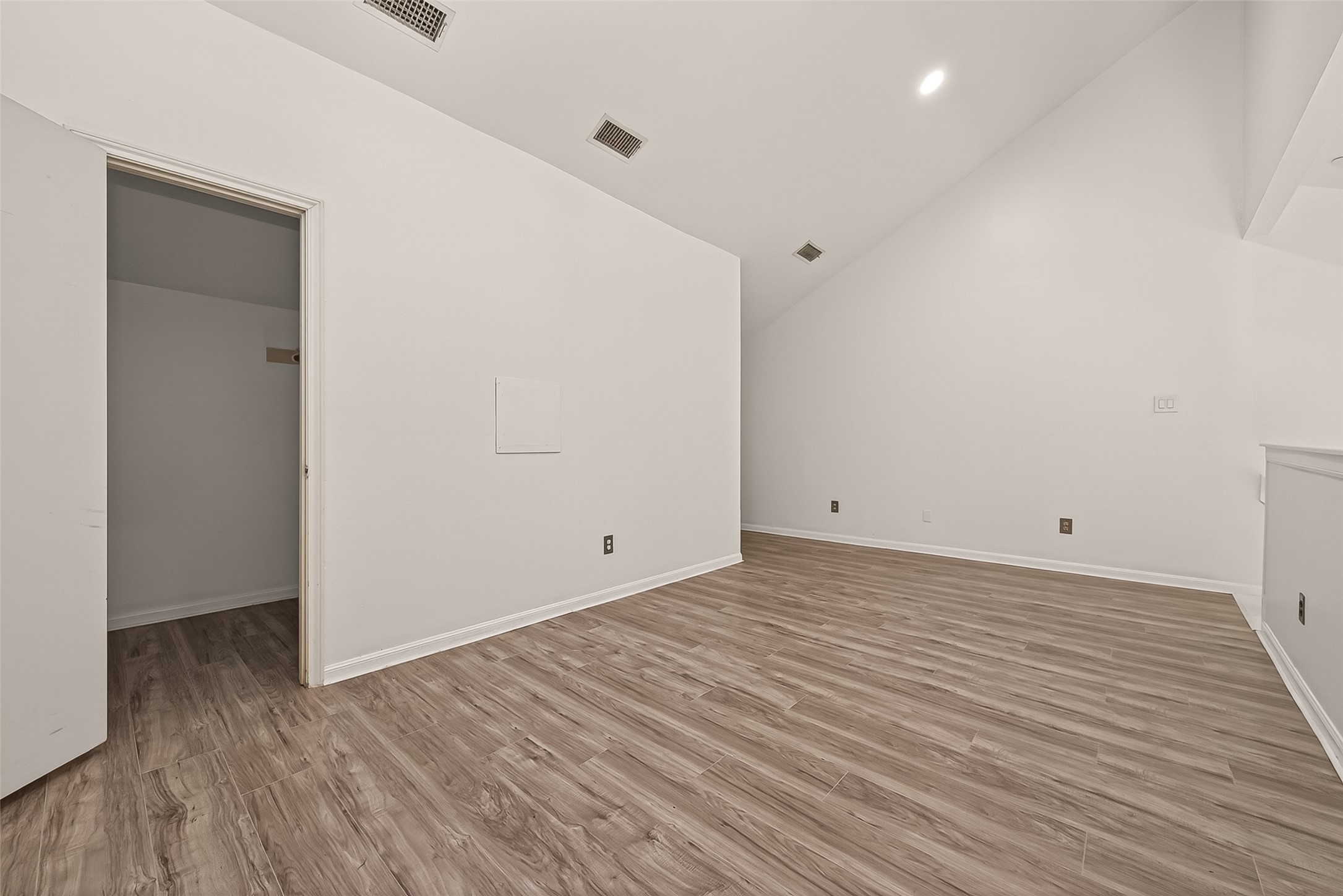 180 April Point Drive South Conroe, TX 77356 - Photo 28 of 39 This room features a sloped ceiling, wood-look flooring, and neutral walls. It includes a small closet and recessed lighting, offering a versatile space.